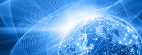 Planet Earth floating in the outer space surrounded by a complex computer network of glowing nodes connected by bright lines: global business and technology connect everything with the Internet of Things. The blue space is filled by an abstract waving wired mesh showing a magnetic field that connects everything. Dark blue background. Planet Earth is in the left side, with NOrth America and Europe on top and copy space on left side. Wide angle horizontal image, letterbox format. - IMD Business School