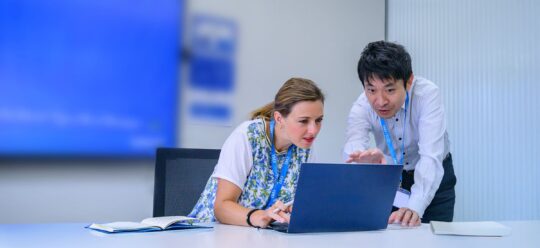 Professional executives engage in a strategy session with digital tools, representing AI and digital business transformation. - IMD Business School